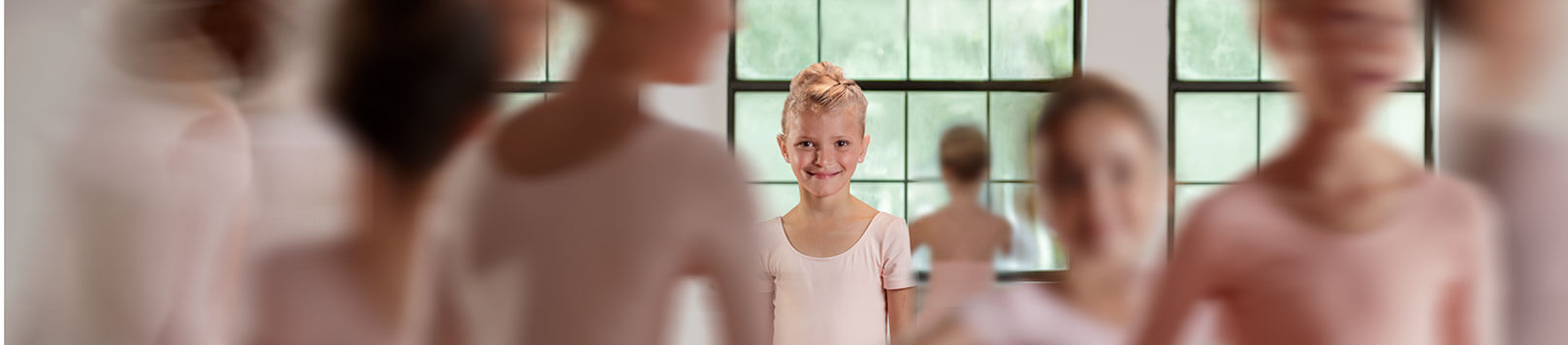 Young girl smiling with other girls out of focus